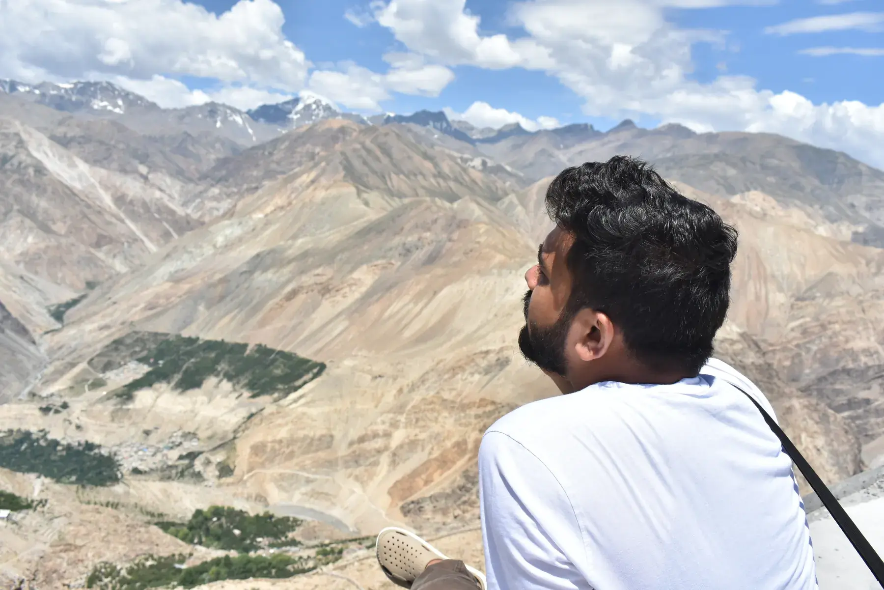 Looking out from a ledge above Nako across the valley to a line of snow-covered peaks